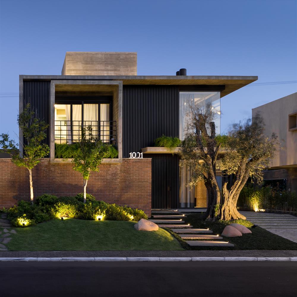 Retrofit de fachada de casa com esquadrias pretas e placas de